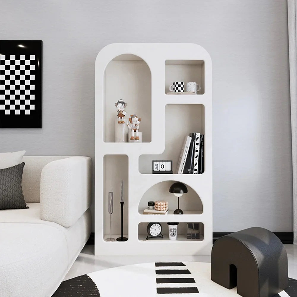 The Minimalist Cream Wind Sculptural Shelf, styled with decor, stands beside a cream sofa in a modern living room, showcasing French cream wind style with subtle monochrome accents.
