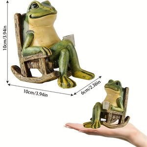 A charming Solar-powered Rocking Chair Frog Light, featuring a small frog sitting on a rocking chair and holding a book, is displayed with dimensions and shown resting on a person’s hand for scale—making it the perfect outdoor decor to brighten your space.