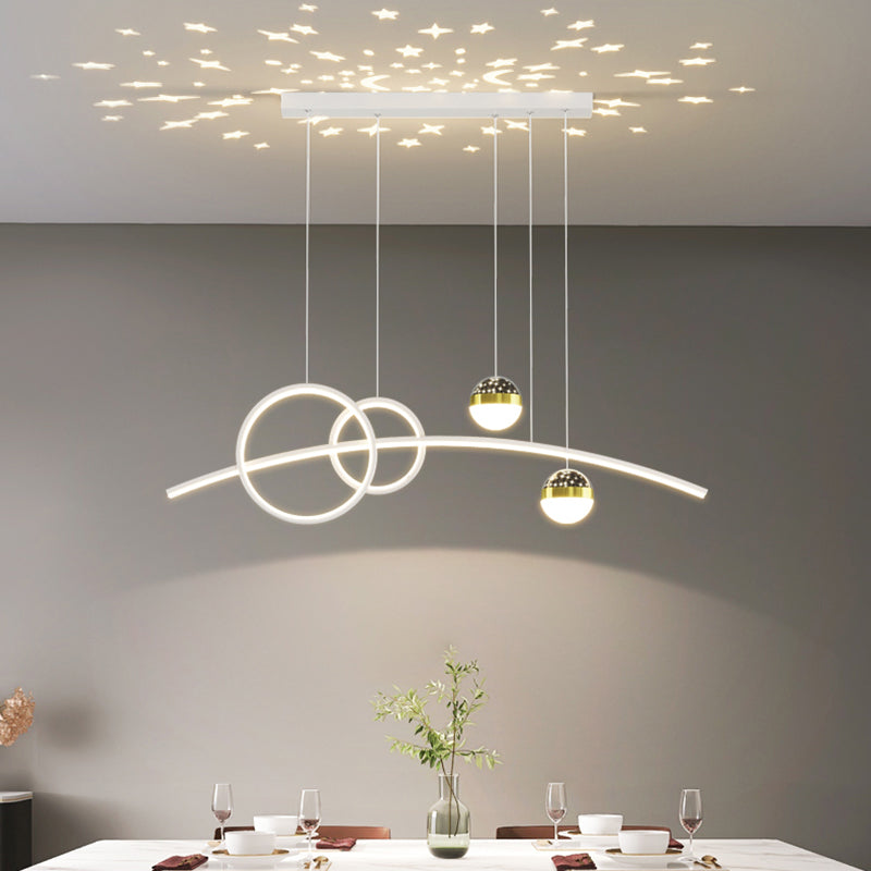 The Stellar Pendant Light features hanging orbs that create celestial accents and star-shaped reflections, perfect for illuminating a dining table set with dishes and wine glasses.