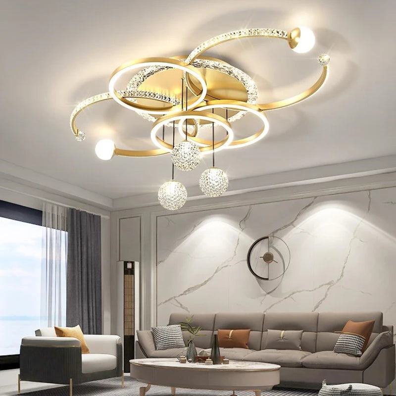 Modern living room featuring the Elegant Multi-Ring Ceiling Light in a sculptural circular LED chandelier design, complemented by a grey sofa, glass coffee table, marble accent wall, and a large window with sheer curtains.