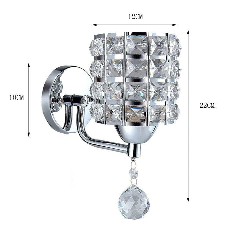 The Luxury Cylinder Wall Light features a crystal design with a decorative hanging crystal, measuring 22 cm high, 12 cm wide, and 10 cm deep for an elegant modern touch.