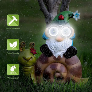 A Solar Gnome Snail Light featuring a garden gnome with glowing eyes perched on a snail sits beside a charming green snail figure in the rain—perfect as outdoor gnome decor. Icons highlight that this product is made of durable resin, is eco-friendly, and waterproof (IP68), making it an ideal garden solar light for any weather.