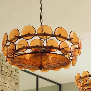 The Italian Retro Pendant Light features circular amber glass discs on a metal frame, highlighting Italian artisan lighting with a large matching amber disc at the base in a Mid-Century Modern style.