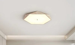 Natural Stone Ceiling Light featuring a hexagonal shape with a white diffused cover and beige frame, inspired by wabi-sabi lighting, mounted on a smooth white ceiling in a modern room.
