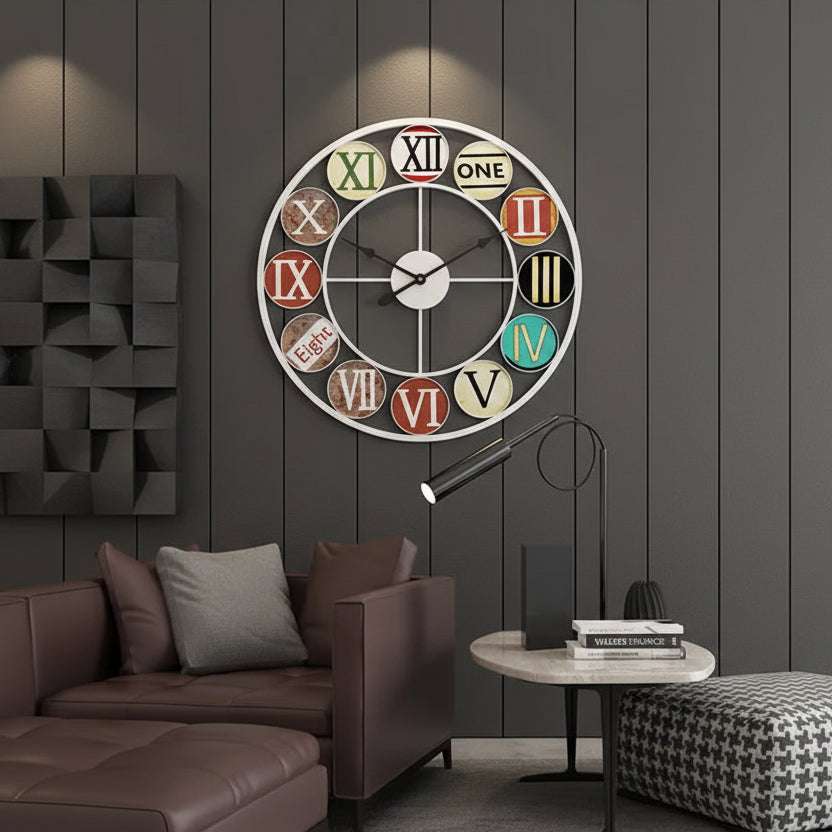 The Nordic Color-Ring Wall Clock, featuring colorful panels and a blend of Roman numerals and words, is displayed above a brown sofa in a modern living room with dark paneled walls.