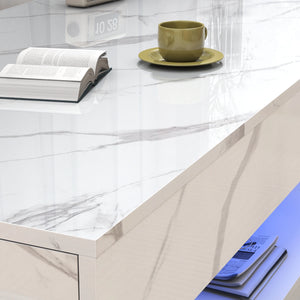 A green cup and saucer, an open book, and a closed book rest on the Premium Coffee Table with a marble-gloss finish and grey veining; magazines are stored on its lower shelf.