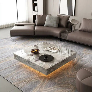 Modern living room featuring the Modern Luxe Coffee Table with underlighting, a gray sectional sofa, abstract wall art, and a textured area rug—ideal for fans of contemporary interiors.