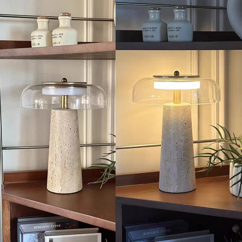 The Mushroom Desk Lamp, featuring a natural stone base and glass shade, is displayed on a shelf—unlit on the left and glowing on the right—accompanied by decorative accents. This lamp infuses the space with warmth, seamlessly merging organic materials with contemporary style.