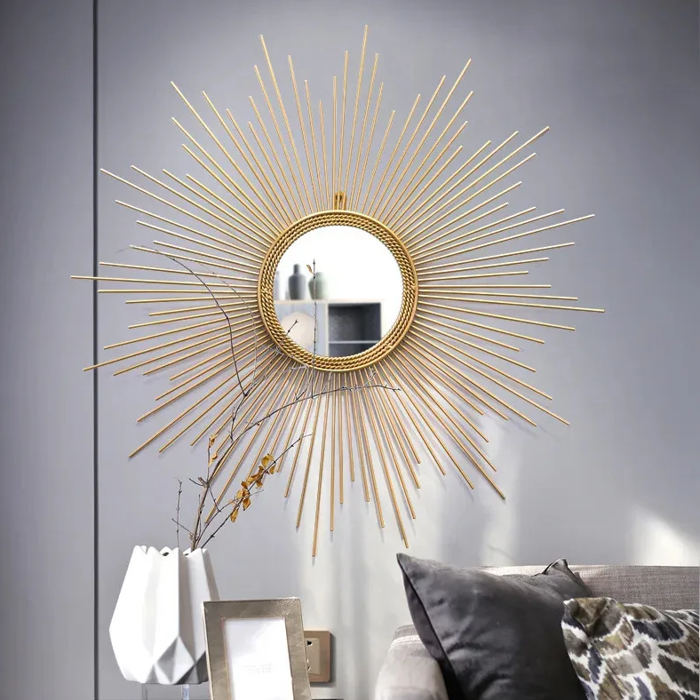 A Luxe Sunray Wall Mirror with a sunburst frame hangs on a gray wall above the sofa, creating a striking focal point beside a white lamp, framed photo, and patterned cushion.