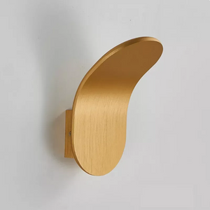 The Curved Wall Light is a modern, curved wooden wall fixture mounted on a white wall, inspired by the elegance of Nordic wall lamp designs.