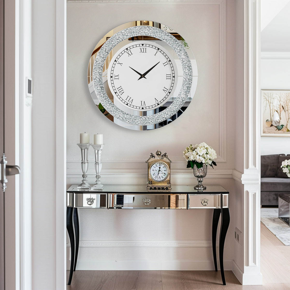 A Modern Luxury Roman Numerals Wall Clock shows 10:10 above a decorative console table with candles, a clock, and a flower vase in an elegant, modern hallway.