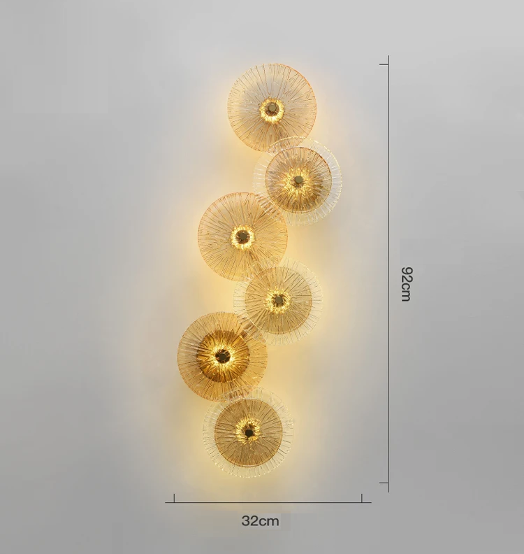 The Amber Deco Wall Sconce is a nature-inspired LED wall light with seven vertically stacked, gold-toned circles. It measures 92 cm high and 32 cm wide.