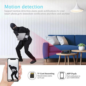 A masked intruder holding a laptop is recorded in a living room; the same footage appears on a phone screen, showcasing Motion Detection alerts from the SpyCam Camera Clock.