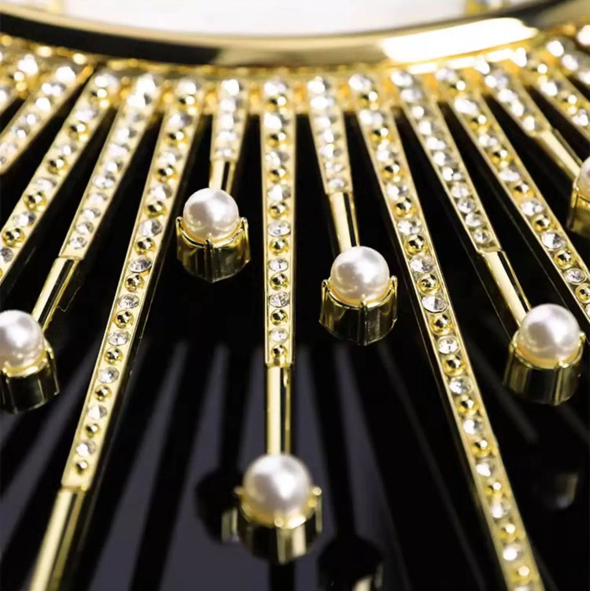 Close-up of the Premium Sun Wall Clock: gold rods with crystals and pearls radiate on a glossy black face, creating an elegant sunray-inspired design.