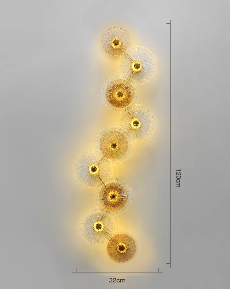 The Amber Deco Wall Sconce features ten vertically arranged circular glass discs and emits a warm yellow glow; it measures 120 cm in height and 32 cm in width.