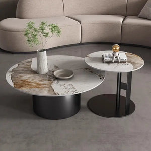 Two Premium Round Coffee Tables with marble tops are placed side by side; one features a vase with greenery and a dish, while the other displays stacked books and a gold accent piece.