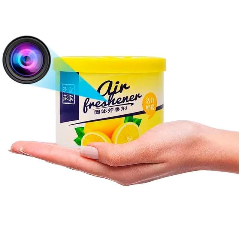 Hand holding a container of Fake Decorative Display SpyCam, this high-tech surveillance tool is disguised as a lemon-scented air freshener with a hidden camera lens on the lid.