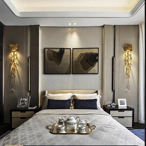 A modern bedroom featuring a neatly made bed, two side tables, and Luxury Vertical Wall Lights casting a warm glow. Above the headboard hangs abstract artwork, while an elegant tea set rests on a silver tray at the foot of the bed, completing this serene retreat.