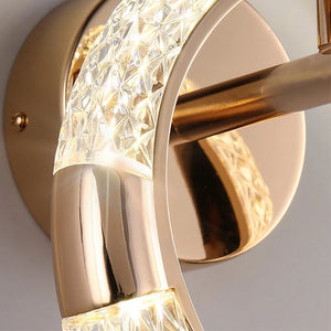 Close-up of an Elegant Ring Wall Sconce, featuring a gold-colored finish with a curved, textured, and illuminated glass design.