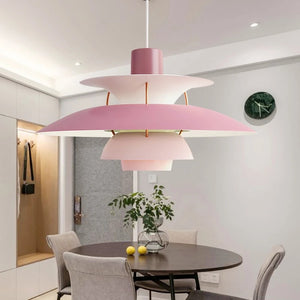 A dining room with a pink pendant light that is a blend of style.