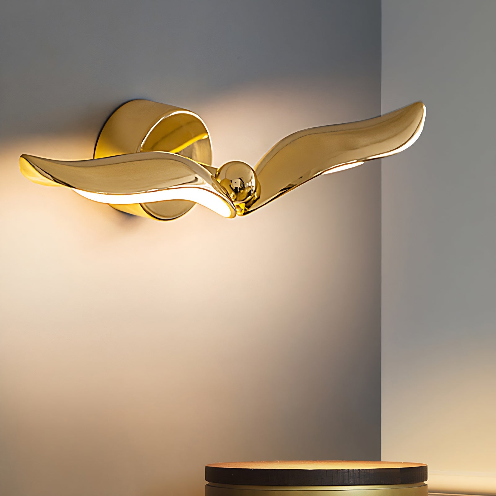 A modern design wall light in the shape of a gold wing of a bird, perfect for adding an artistic touch to any interior.