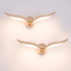 A pair of modern design gold wing shaped wall lights to mimic two birds flying in the sky, perfect for adding a unique touch to any interior space.
