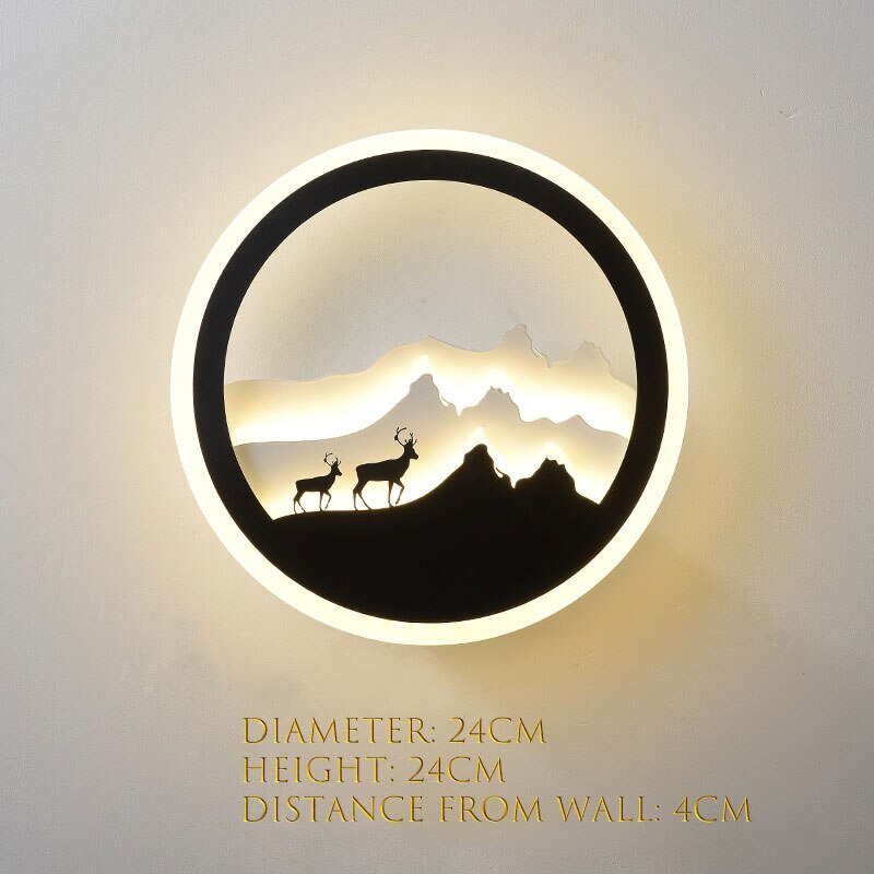 The Minimalist Wall Lamp showcases a mountain and deer silhouette, emitting a gentle and inviting glow. Ideal for contemporary homes, it has dimensions of 24cm in both diameter and height, with a 4cm projection from the wall.