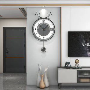 A modern style TV stand is adorned with decorative items, including ceramic animals and a small figure, while an Antler-like Wall Clock adds a nature-inspired touch above. A closed door is in the background.