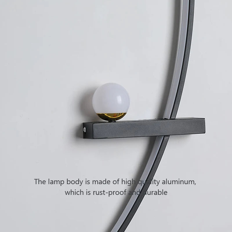 A stylish and modern lighting choice, the Arc Wall Sconce showcases a spherical white bulb elegantly mounted on a minimalist black metal bracket against a light gray wall. Below the sconce, text reads, "The lamp body is made of high-quality aluminum, which is rust-proof and durable.
