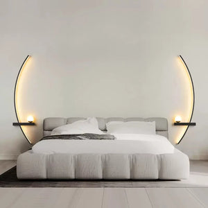 A modern bedroom features a low-profile bed adorned with white bedding, flanked by elegant Arc Wall Sconces and small side shelves topped with glowing orbs. The room boasts a minimalist, clean design.