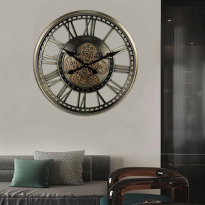 The Steampunk Wall Clock, showcasing its exposed gears, infuses an industrial vibe as it hangs above a modern sofa adorned with green and patterned pillows in the living room.