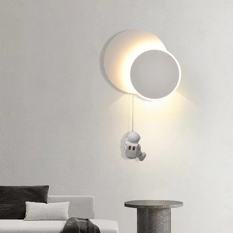 Modern Star Astronaut Wall Light illuminating a room with a small astronaut pendant hanging from the light, where design meets imagination.