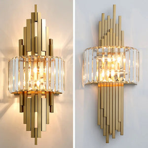 A pair of Luxury Geometric Wall Sconces with vertical modern gold frames, featuring clear glass rods and multiple light bulbs, are mounted on a white wall, creating an elegant Art Deco style fixture for home decor.