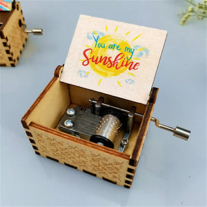 This Music Box - You Are My Sunshine, crafted from wood, has its lid open. The lid displays the heartfelt text "You Are My Sunshine" accompanied by a charming sun illustration, revealing the intricate inner mechanism of one of the finest wooden music boxes.