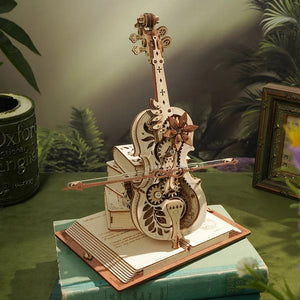 A detailed 3D wooden puzzle of the Cello Puzzle Music Box, featuring gears and intricate carvings, displayed on an open book and surrounded by greenery and some books.