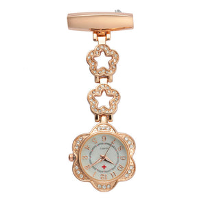 The Luxe Fob Pocket Watch features a gold finish, floral rhinestone design, white dial with red cross symbol, and vertical hanging clasp. Sparkling crystal accents add extra elegance to this stylish nurse accessory.