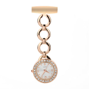 The Luxe Fob Pocket Watch features a gold-toned circular face with crystal accents and a chain connecting to a beige pin bar—offering a stylish upgrade from traditional silver fob watches.