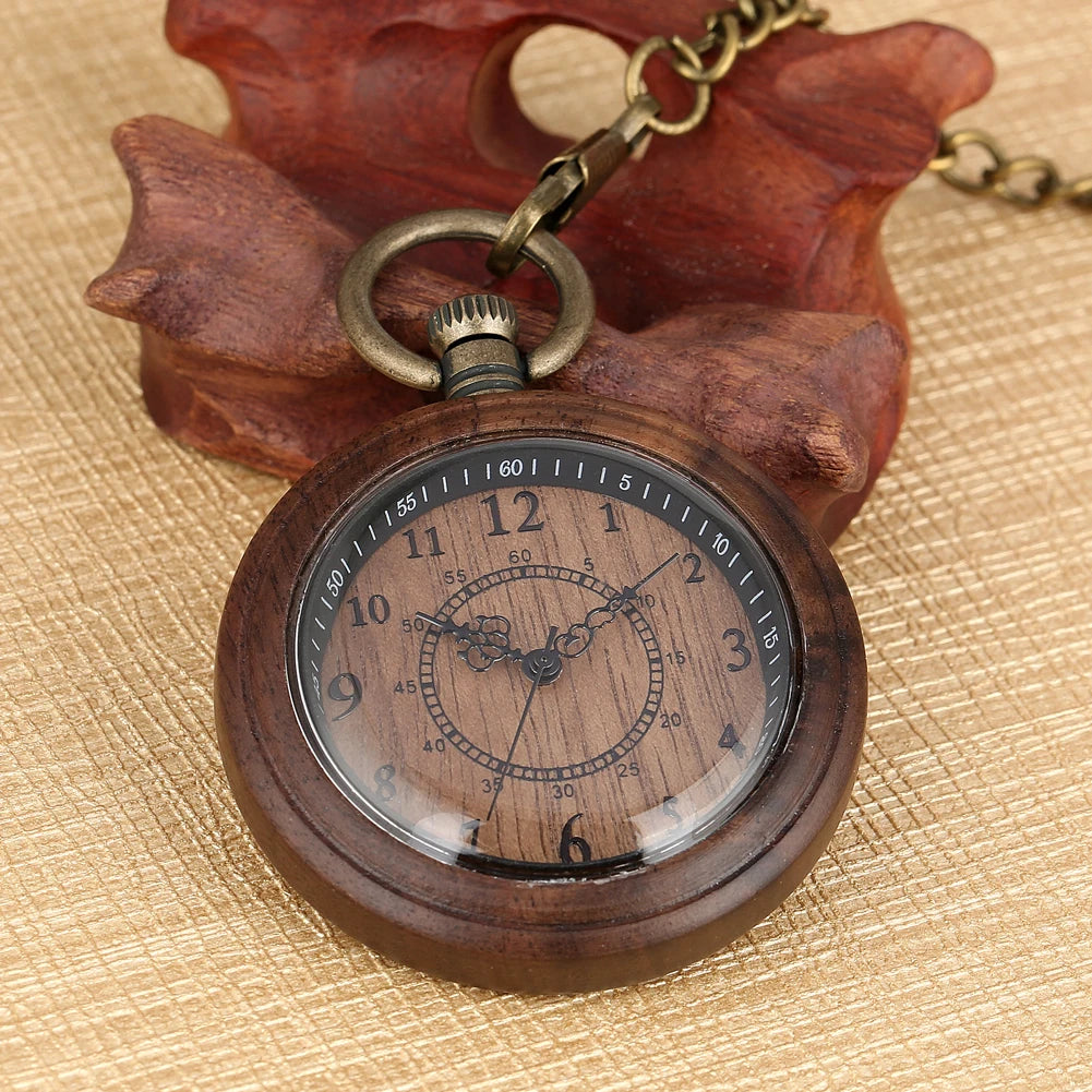 The Wooden Pocket Watch features black numerals and ornate hands on a round wooden face, displayed on a carved leaf-shaped wooden holder atop a textured beige surface.