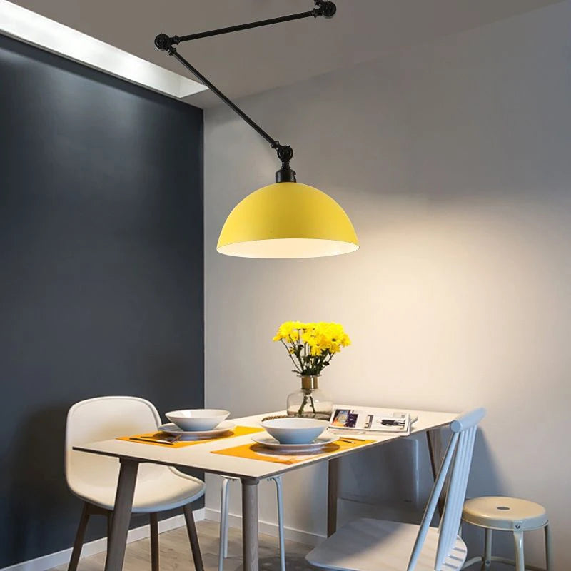 Modern dining set for two includes white bowls and placemats. The table is adorned with yellow flowers in a vase and illuminated by the Zig Zag Pendant Light, enhancing the sleek, minimalist room infused with industrial design elements.