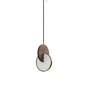 The Dual Disc Pendant Light, with its geometric design, features a circular white shade and wooden accent. It suspends from a black cord against a white background to enhance any sophisticated home aesthetic.