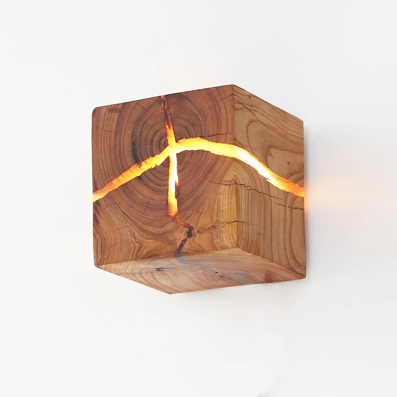 Wood Cube Wall Light featuring visible glowing cracks exudes a contemporary design against a plain background, perfectly highlighting the natural wood grain.