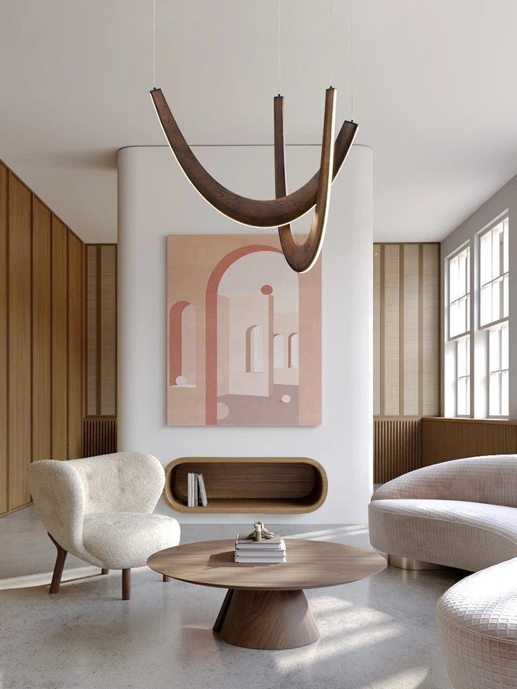 Modern living room with neutral tones, curved furniture, abstract wall art, a round wooden coffee table, and the Double Curve Wood Pendant Light as a striking modern centerpiece.