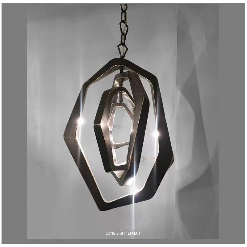 The Elegant Industrial Gallery Pendant is a modern rose gold fixture with geometric metal shapes and multiple LED pendants, suspended by a chain against a gray background.