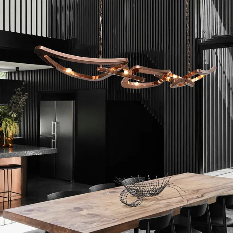 Modern dining area with a wooden table, wire fruit bowl, and sleek black kitchen with vertical slat walls, highlighted by the Elegant Industrial Gallery Pendant light fixture above.