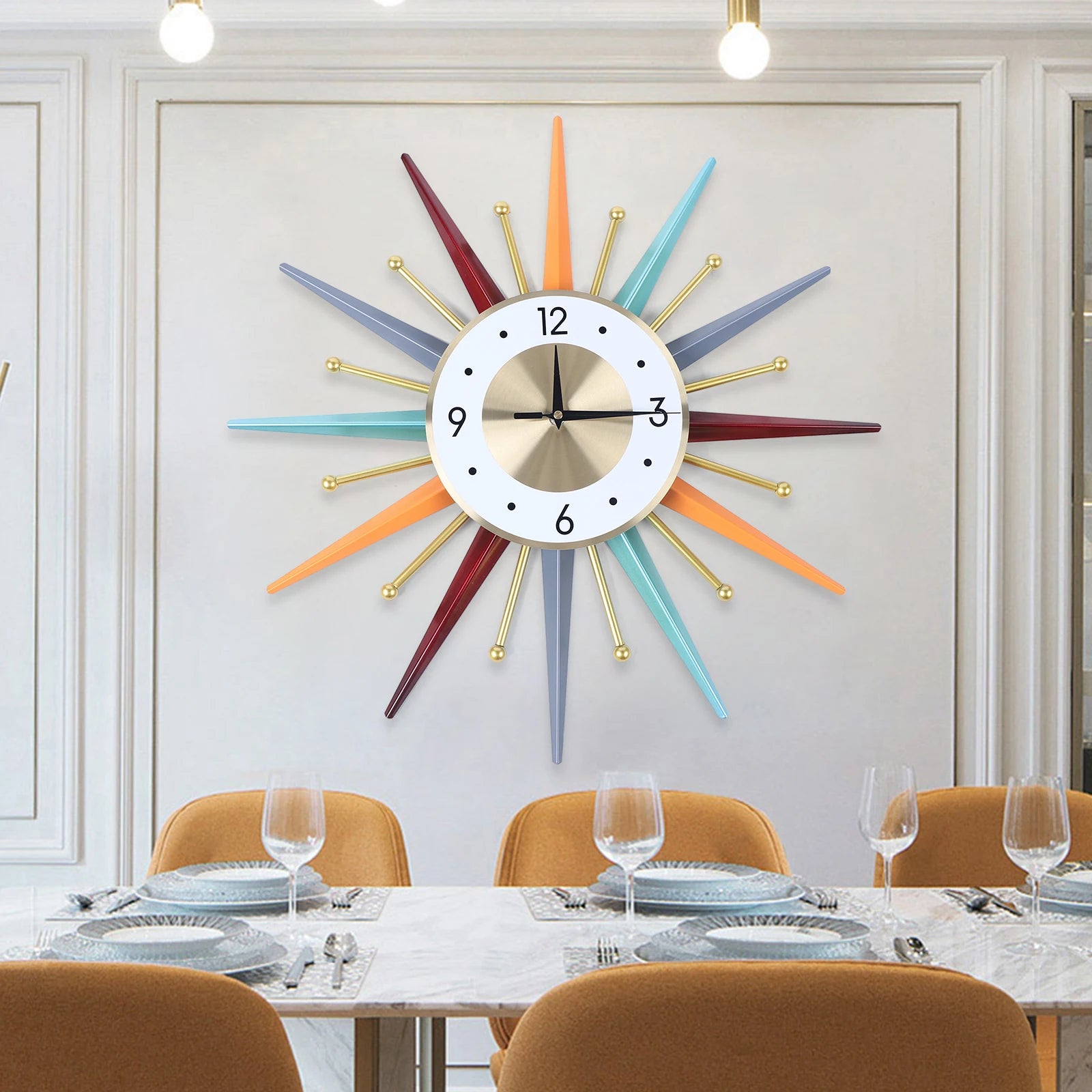 A modern dining room showcases the Sunburst Wall Clock with radiant rays above a set table featuring orange chairs and stylish place settings.