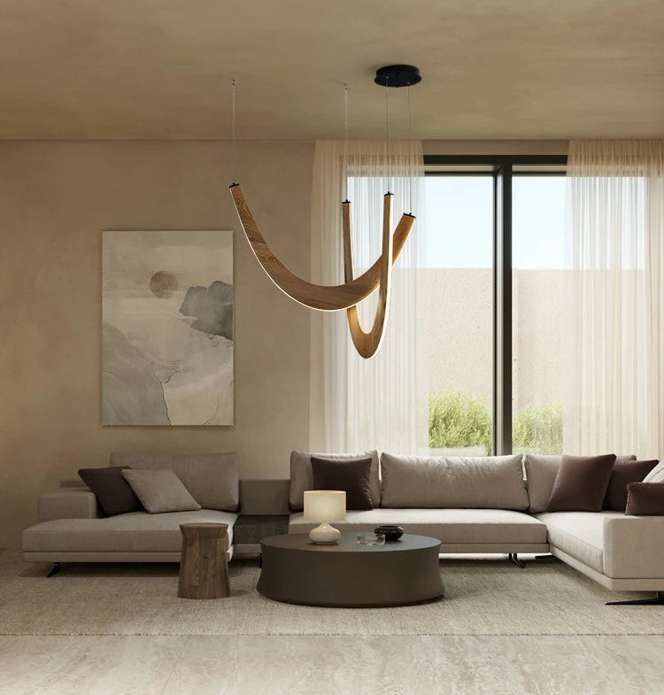 Minimalist living room with neutral-toned sofas, a round coffee table, abstract wall art, large window with sheer curtains, and the Double Curve Wood Pendant Light providing a warm, elegant glow.