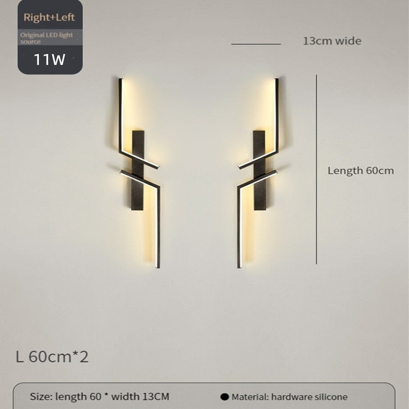Two Minimalist Wall Sconce lights with geometric black metal designs, each measuring 60cm by 13cm, are mounted on the wall. They provide warm LED illumination for stylish and modern decorative wall lighting.