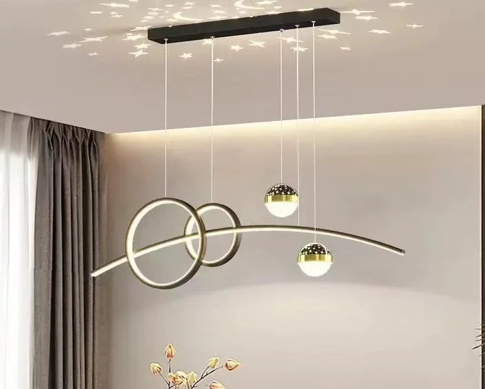 The Stellar Pendant Light, a modern fixture with celestial accents, features dual rings and three suspended globes. It hangs elegantly, emitting a warm glow and casting star-like reflections on the ceiling with geometric illumination.