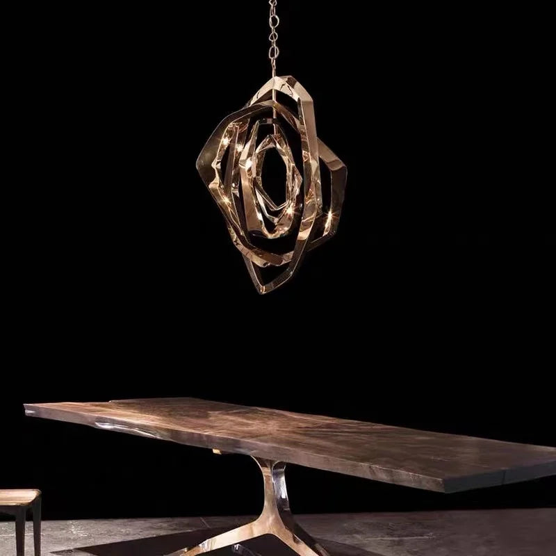 An Elegant Industrial Gallery Pendant casts abstract metallic shadows over a wooden table with a uniquely shaped metal base, all set against a black background.
