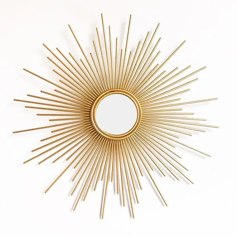 The Luxe Sunray Wall Mirror features a round design with a gold sunburst frame and metal rods of varying lengths, making it a perfect statement piece for modern interiors.